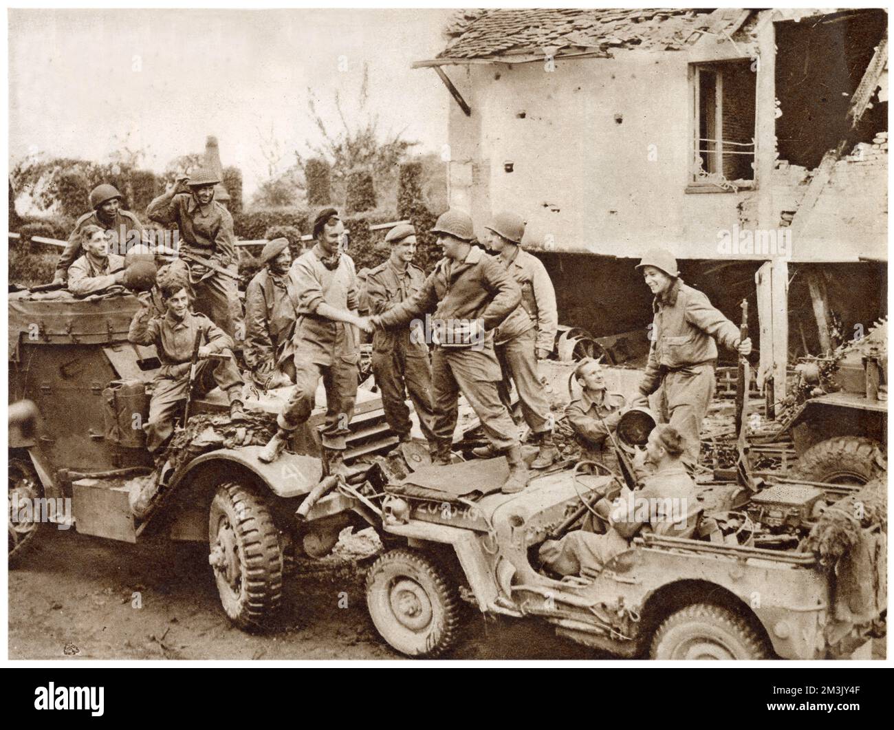 The meeting between American troops (on right with jeep) and Canadian troops (on left with half-track) to mark the closing of the 'Falaise Pocket' on the road between Falaise and Argentan, France, 1944.  By closing the gap at Falaise, the Allied forces had completed their attempt to encircle the German Fifth Army and Seventh Panzer Army. Stock Photo