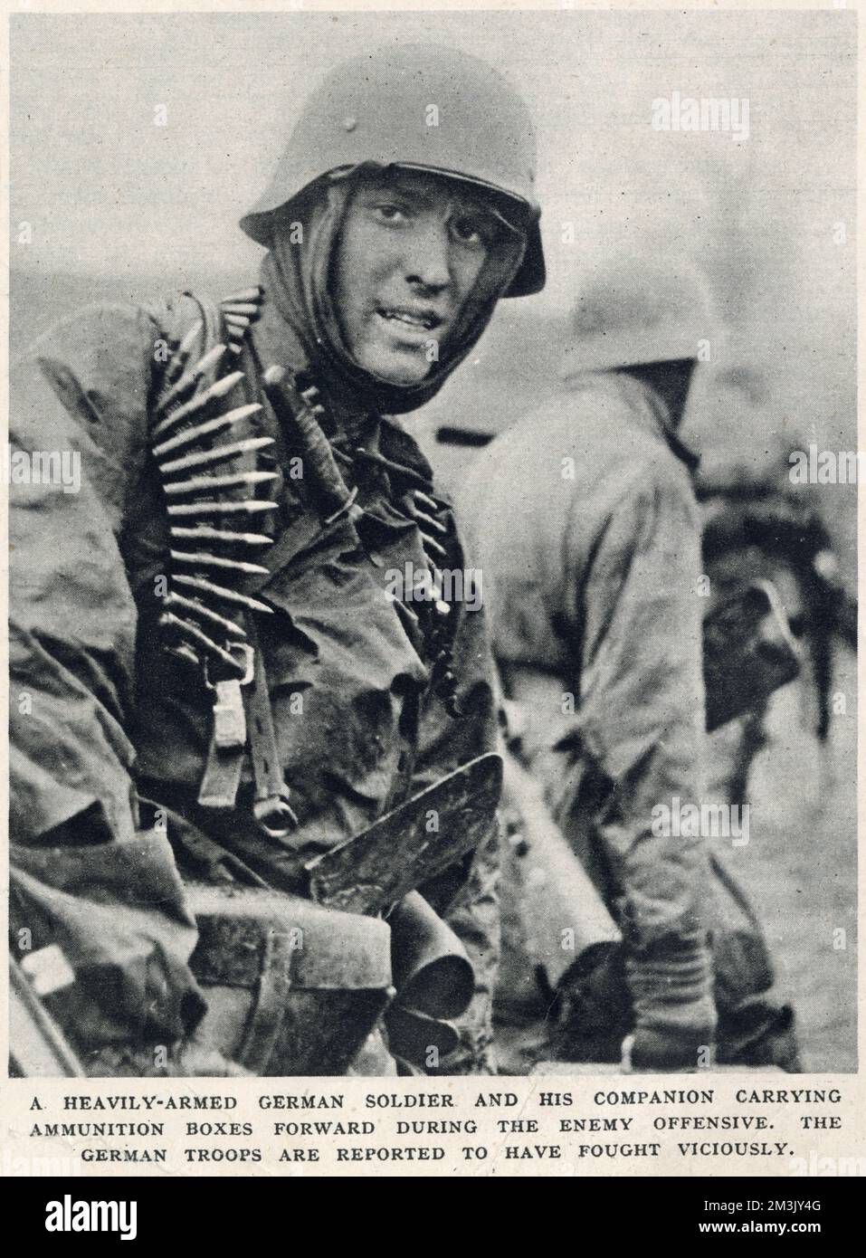 Photograph showing a German SS infantryman and his companion carrying ammunition boxes forward, during the early stages of the 'Battle of the Bulge', December 1944.  The 'Battle of the Bulge' was the last major Nazi offensive on the Western front during the Second World War and, though initially successful, resulted in major German losses.  This photograph was taken by a German film unit during the German offensive. The film was then captured during the Allied counter-offensive. Stock Photo