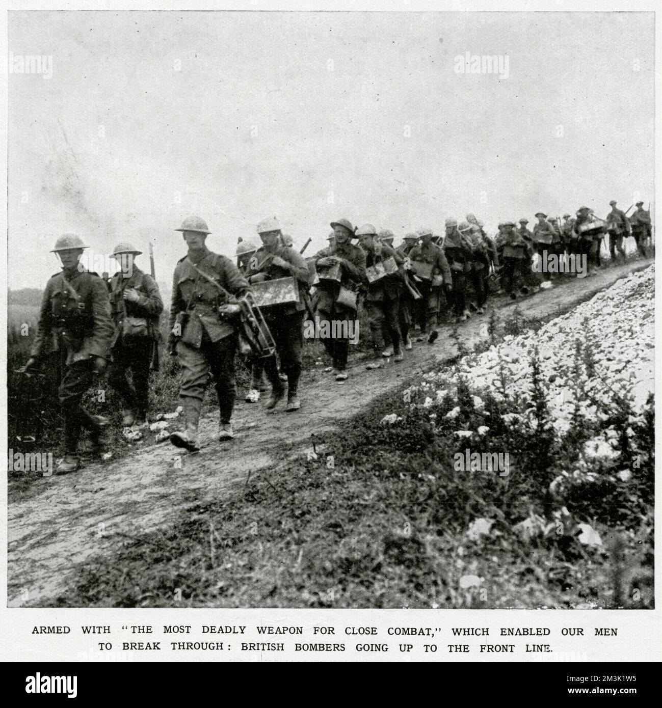 British grenadiers, armed with what the caption described as 'the most deadly weapon of this murderous war,' marching towards the front lines in July 1916. Stock Photo