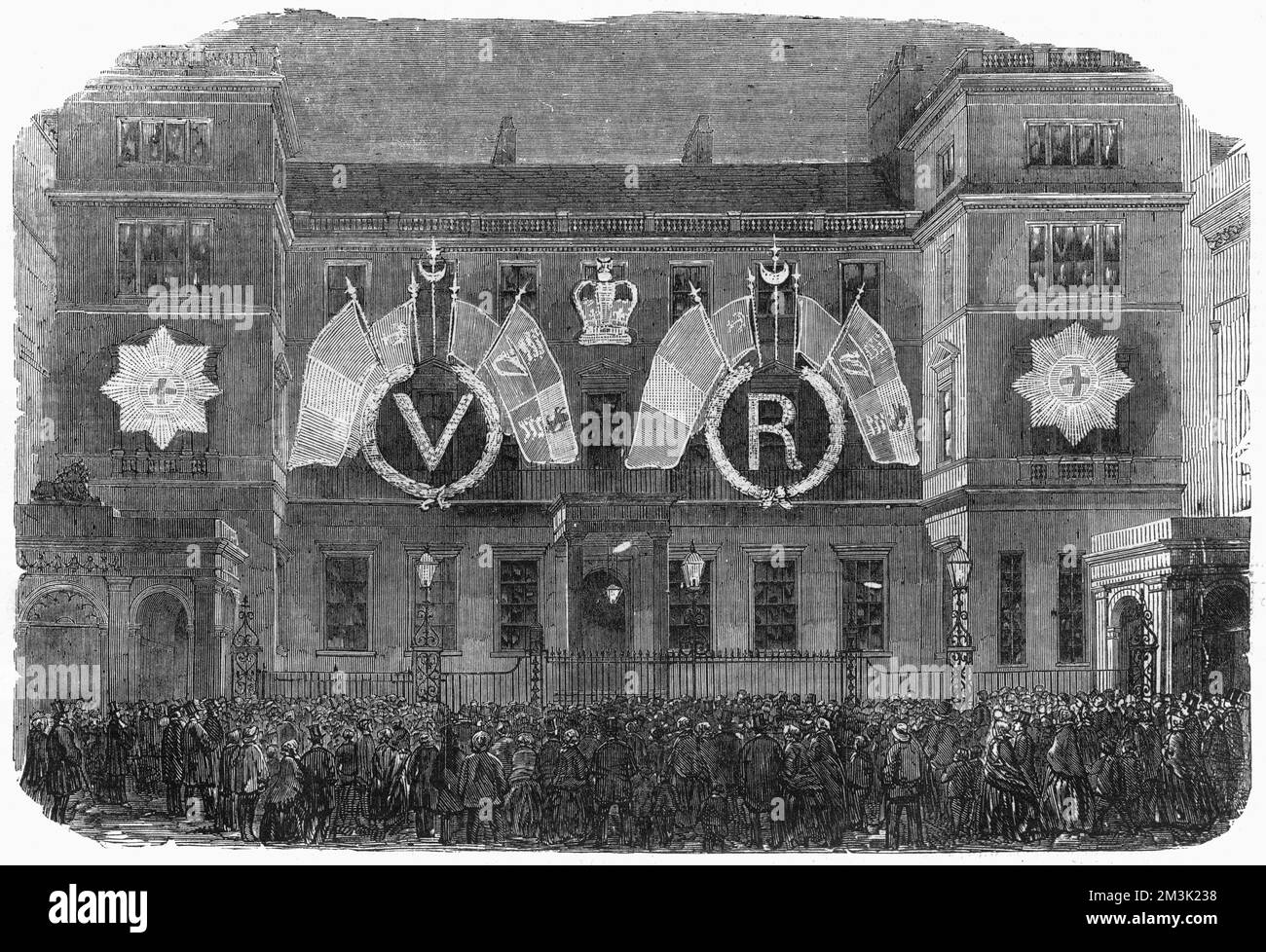 Fireworks and illuminations cheered the populace on the cessation of hostilities in the Crimean War. In this engraving the Ordnance Office, Pall Mall, London is illuminated with images of the garter and the Queen's insignia, VR.  1856 Stock Photo