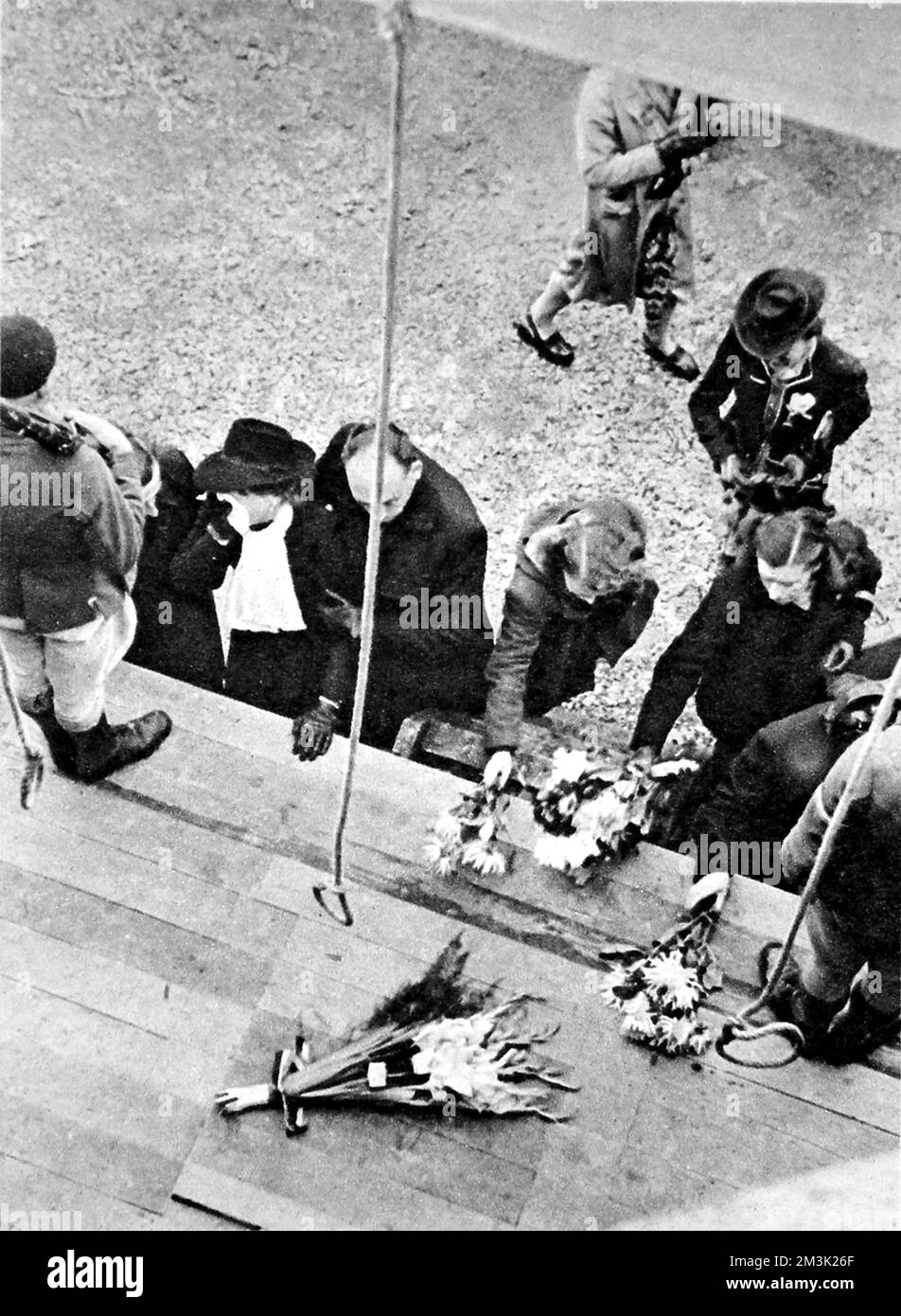 Photograph showing Dutch civilians laying flowers on the gallows at Breendonck fort, Belgium, 1944.    This fort, situated between Brussels and Antwerp, was used by Nazi security services during their occupation of Belgium between 1940-44.  As such, it was the scene of many Nazi atrocities; the gallows shown had a long drop, designed to slowly strangle victims to death.     Date: 1944 Stock Photo