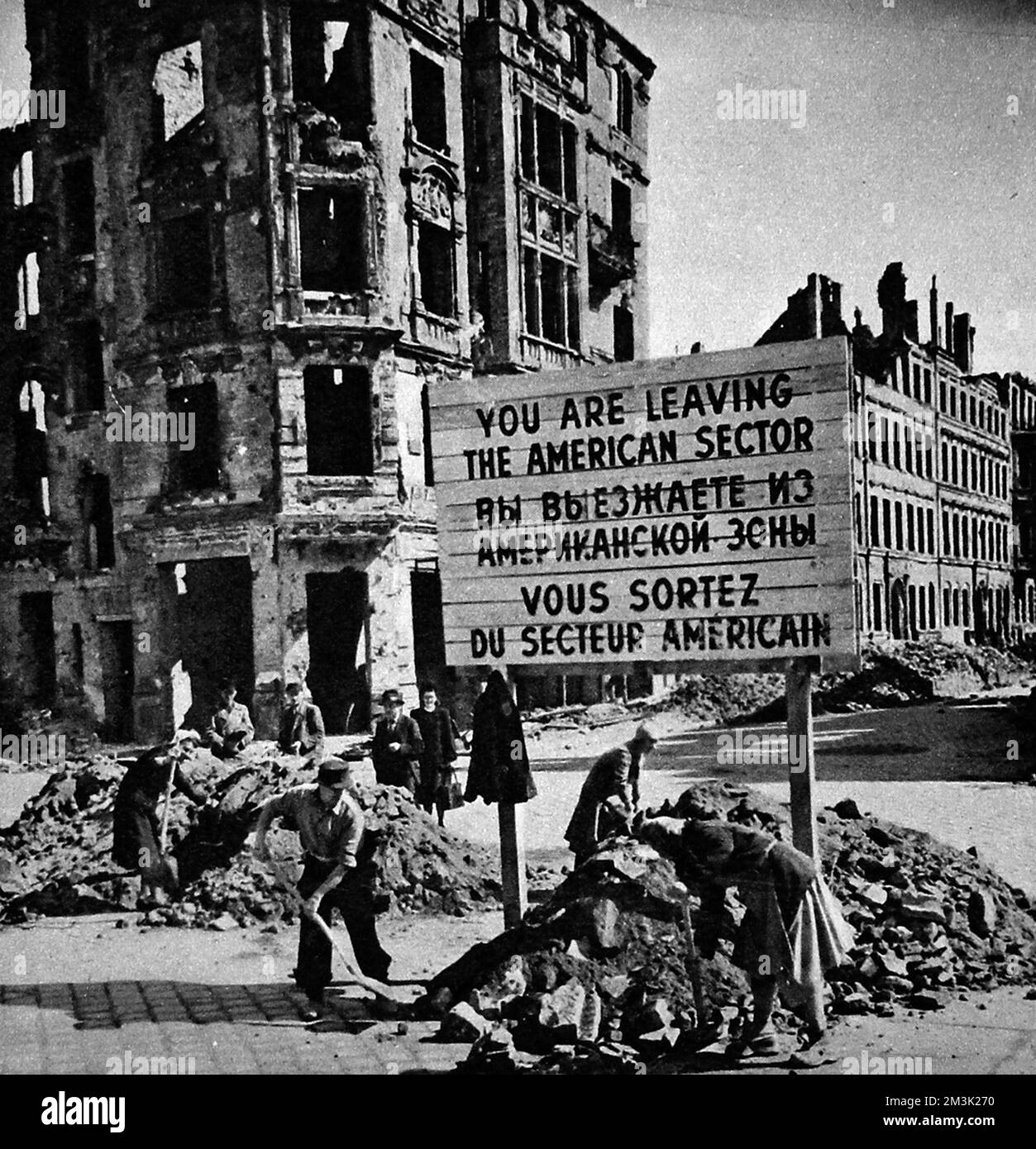 Photograph showing German men and women removing the rubble barricades between the American Sector and the Soviet Sector of Berlin at the end of the Berlin Blockade, May 1949.    Between April 1948 and May 1949 Josef Stalin, leader of the USSR, imposed a land blockade on supplies from Western Europe to West Berlin.  In response the British and American governments organised an enormous airlift to supply food and other essentials to the 2.5 million inhabitants of West Berlin.  After a year Stalin conceded defeat and lifted the blockade.     Date: 1949 Stock Photo