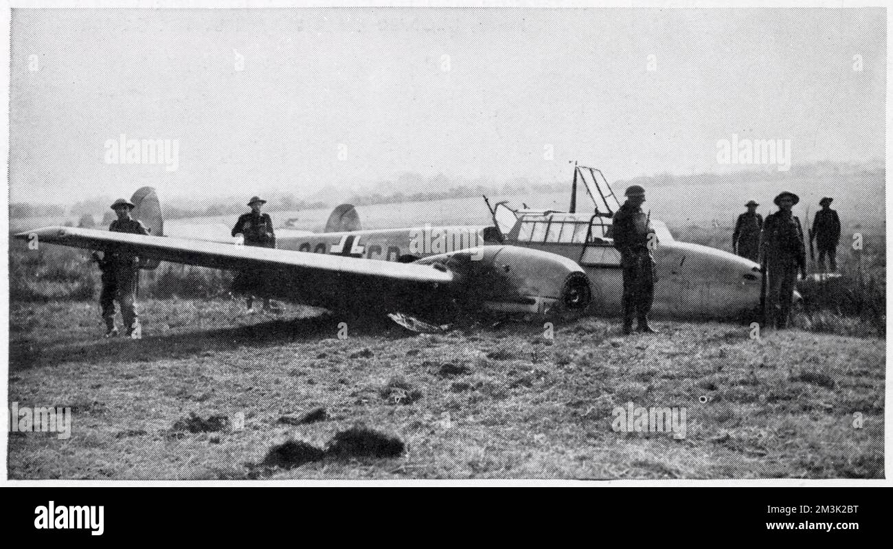 German Messerschmitt Me-110 fighter-bomber, which crash-landed near Hastings after being shot up by a British fighter, during the summer of 1940. A number of British soldiers can be seen guarding the airplane. Stock Photo