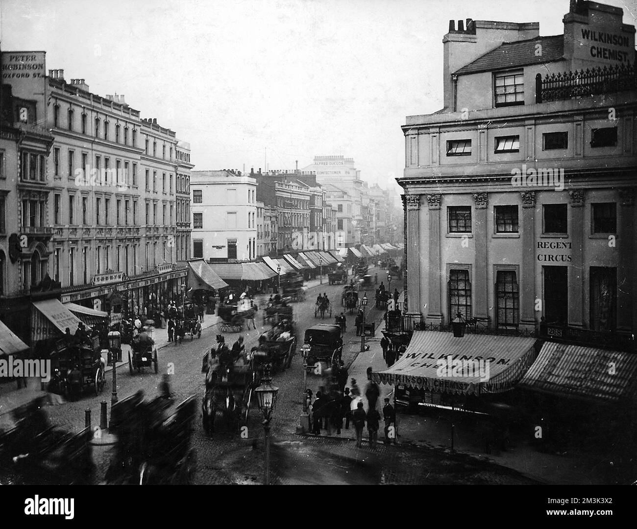 Photograph showing part of Oxford Circus (also known as Regent Circus), London, c.1880.      The horse-drawn carriages travelling along Oxford Street appear blurred, due to the length of exposure used by the photographer.     Date: c.1880. Stock Photo