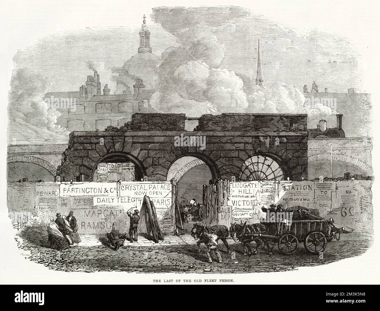 Last remains of Old Fleet Prison, comprising a facade of three archways, London.   In the background a train runs along a railway viaduct and the dome of St. Paul's Cathedral is visible. In the foreground a horse-drawn cart passes a low wall covered with contemporary advertising posters. Stock Photo