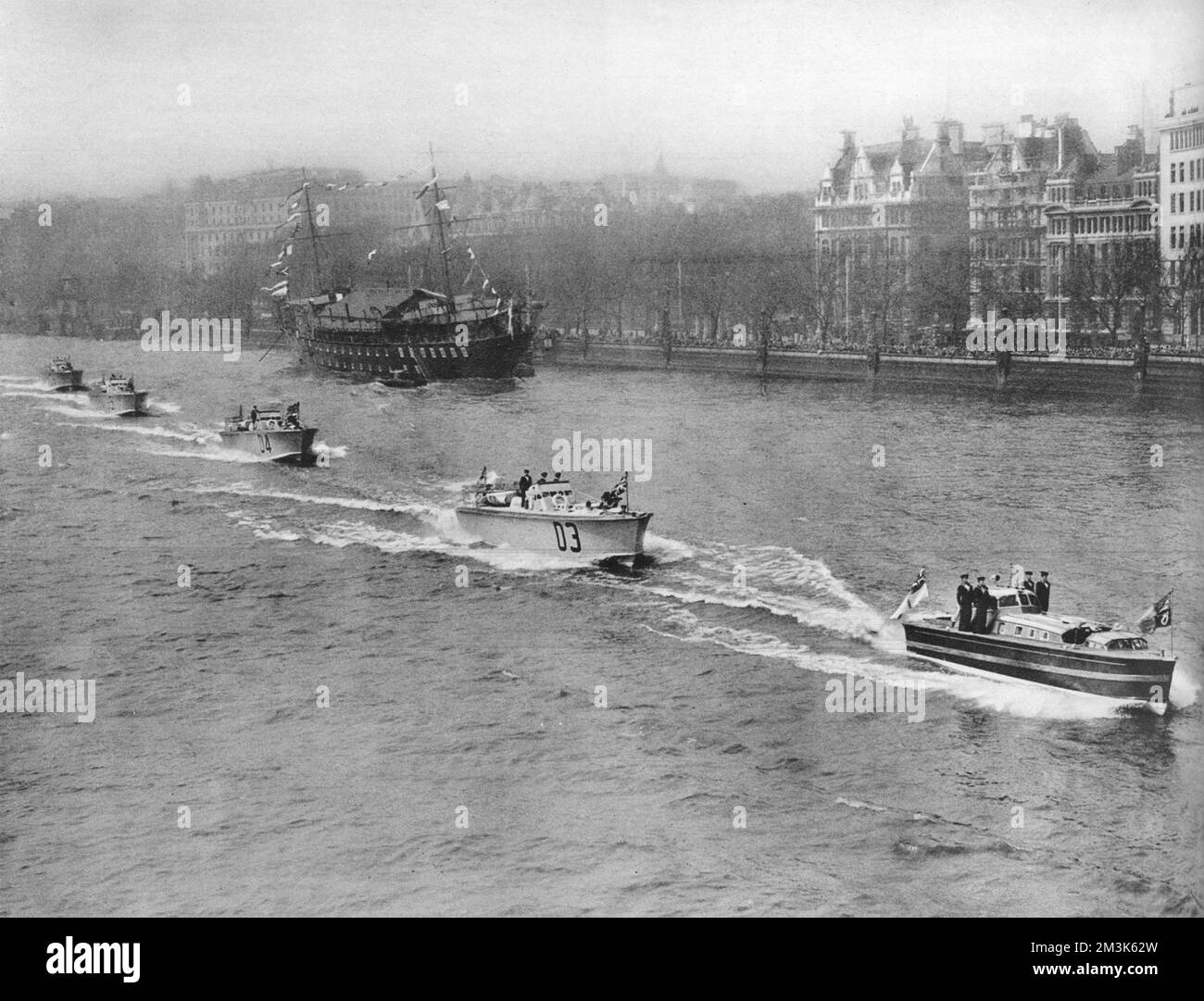 Royal motor barge leading four motor torpedo boats down the River Thames, near Blackfriars, London, 1937.   King George VI, with Queen Elizabeth and Queen Mary, was travelling on board the barge to Greenwich, to open the National Maritime Museum.  The Training Ship 'President' is visible, left background, moored off the embankment.  1937 Stock Photo