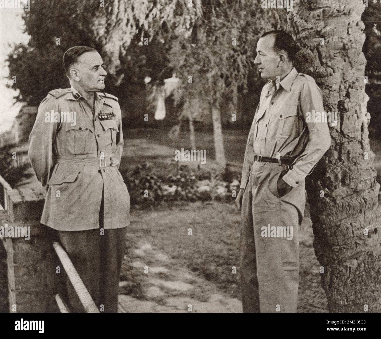 Noel Coward (1899 - 1973) (right), English playwright, actor and composer, talking to Lieut-General Sir H. Pownall during a tour of North Africa in 1943. Coward was then travelling in the region, entertaining British troops. Stock Photo