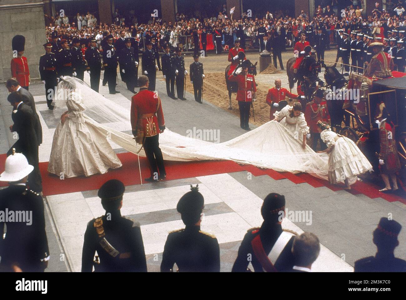 A photograph of Lady Diana Spencer arriving at St Paul's Cathedral in the City of London for her marriage to Prince Charles, Prince of Wales.  Her dress and train, designed by David and Elizabeth Emmanuel is being arranged by her bridesmaids. Crowds of 60000 people lined the streets of London to watch the ceremony on 29th July 1981.     Date: 29th July 1981 Stock Photo