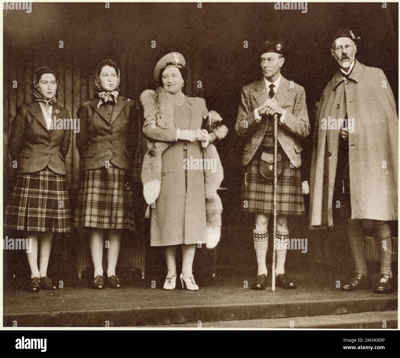 King George VI and Queen Elizabeth, with Princesses Elizabeth and Margaret, with the Marquess of Aberdeen, in the Royal Pavilion at Braemar. It was the first post-war Braemar Gathering and the wettest in memory. 25,000 spectators attended. The King and Princess Elizabeth are seen wearing the Balmoral tartan. Prince Philip of Greece, who was staying at Balmoral, came with the Royal party.     Date: 1946 Stock Photo