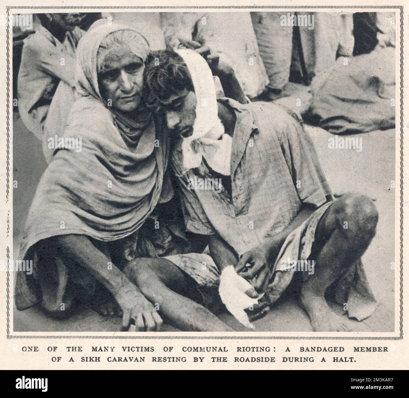 Two victims of communal rioting during the period of the partition of India. Here, a bandaged member of a caravan of sikh refugees rests by the roadside during a halt from the often lengthy and dangerous marches to sanctuary  1947 Stock Photo
