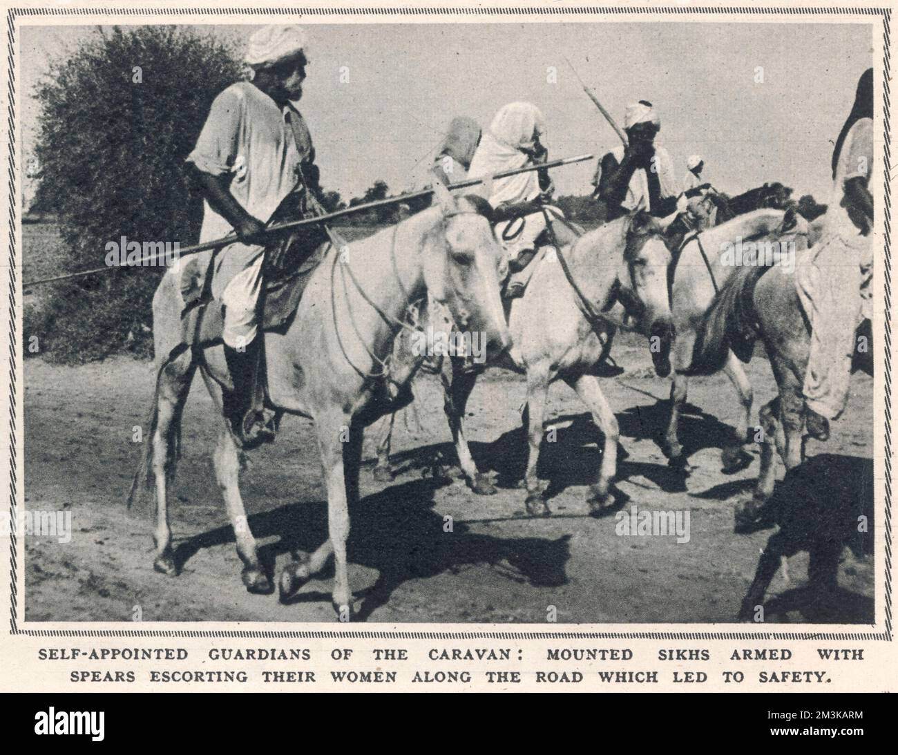 Armed Sikh men on horseback act as the self-appointed guardians fo the column of refugees travelling from East Punjab to Pakistan and safety following the partition of india and the subsequent outburst of violence  1947 Stock Photo