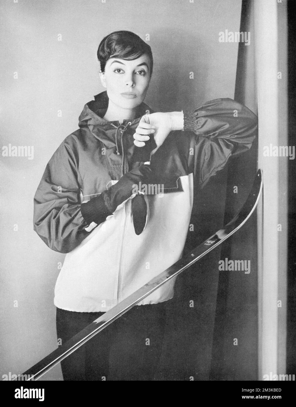 A model poses with skis in a proofed poplin jacket by Gordon Lowe from Debenhams.     Date: 1956 Stock Photo