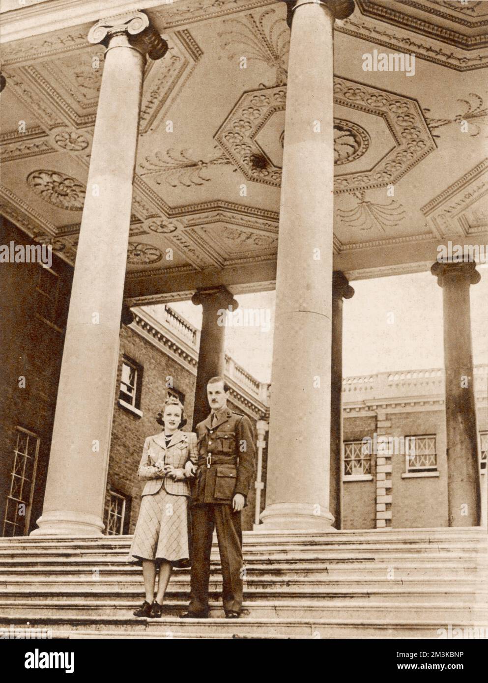 Lord and Lady Jersey (George Child Villiers, 9th Earl of Jersey and his second wife, American actress Virginia Cherrill) on the steps of Osterley Park House in the suburbs of west London. Lord Jersey is home on leave and is in uniform.     Date: May 1940 Stock Photo