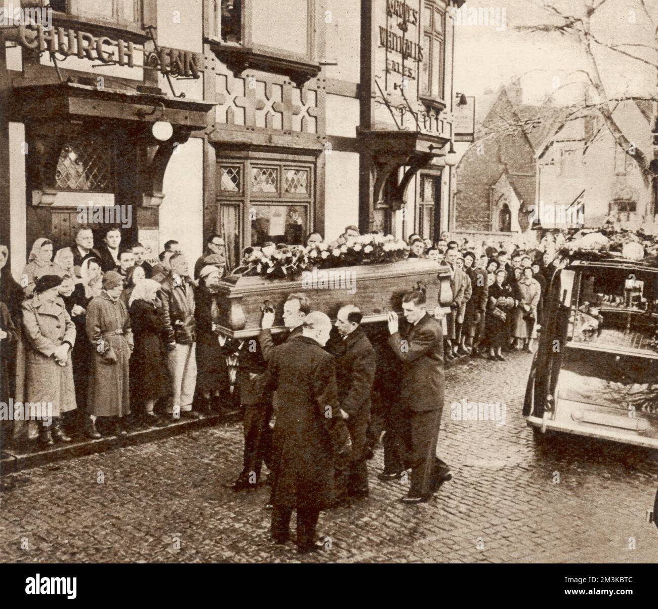 Watched by a large crowd, the body of Roger Byrne, Manchester United captain who died in the Munich air disaster, being carried into St Micheal's Church, Flixton. Huge crowds lined the streets of Manchester on February 10th as the hearses carrying the bodies of the victims drove from the airport to Manchester United football ground at Old Trafford.     Date: 12th February 1958 Stock Photo