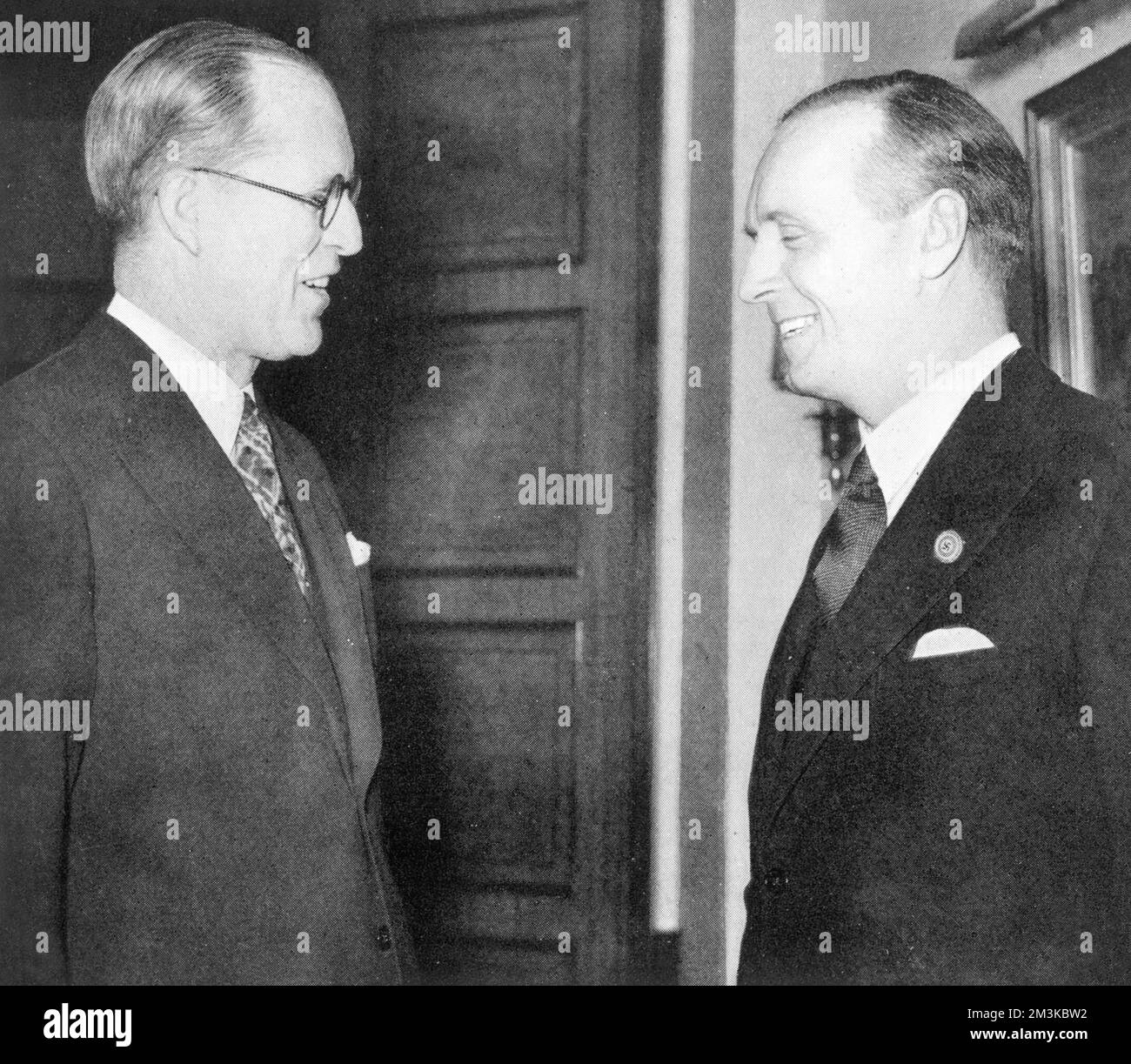 His Excellency, the American Ambassador, Mr Joseph Kennedy (father of John F, Bobby and Edward Kennedy), pictured talking to Herr Joachim von Ribbentrop, Foreign Minister of Germany and former German Ambassador in London, at a farewell reception at the German Embassy in March 1938.       Date: 1938 Stock Photo