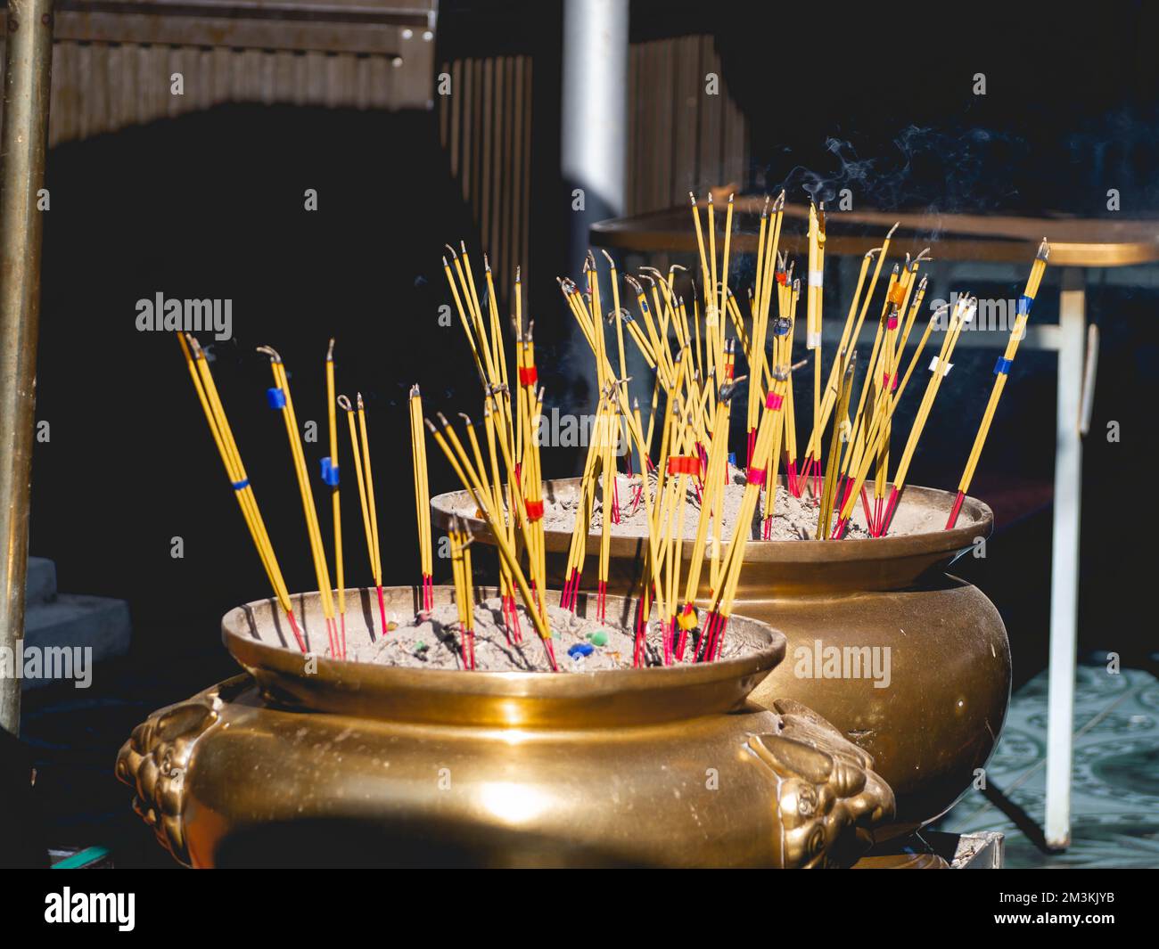 Golden incense burner and many incense sticks in a Thai temple Stock Photo