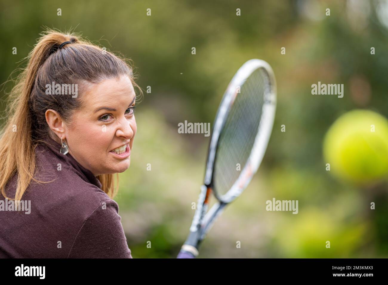 female tennis player practicing forehands and hitting tennis balls on a
