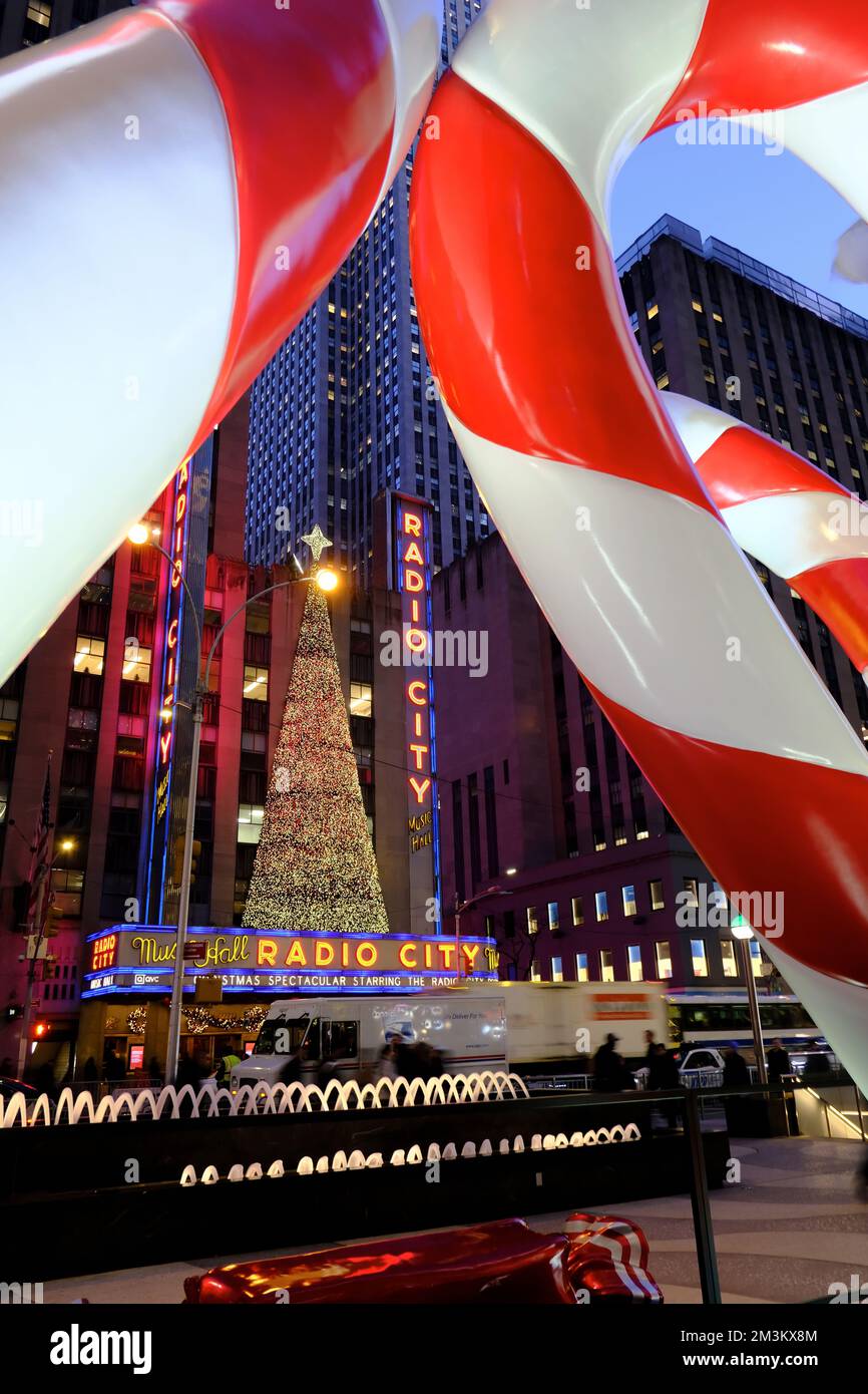 Huge candy canes as Christmas and holiday season decorations with Radio City Music Hall and 6th Avenue in the background.Midtown Manhattan.New York City.USA Stock Photo