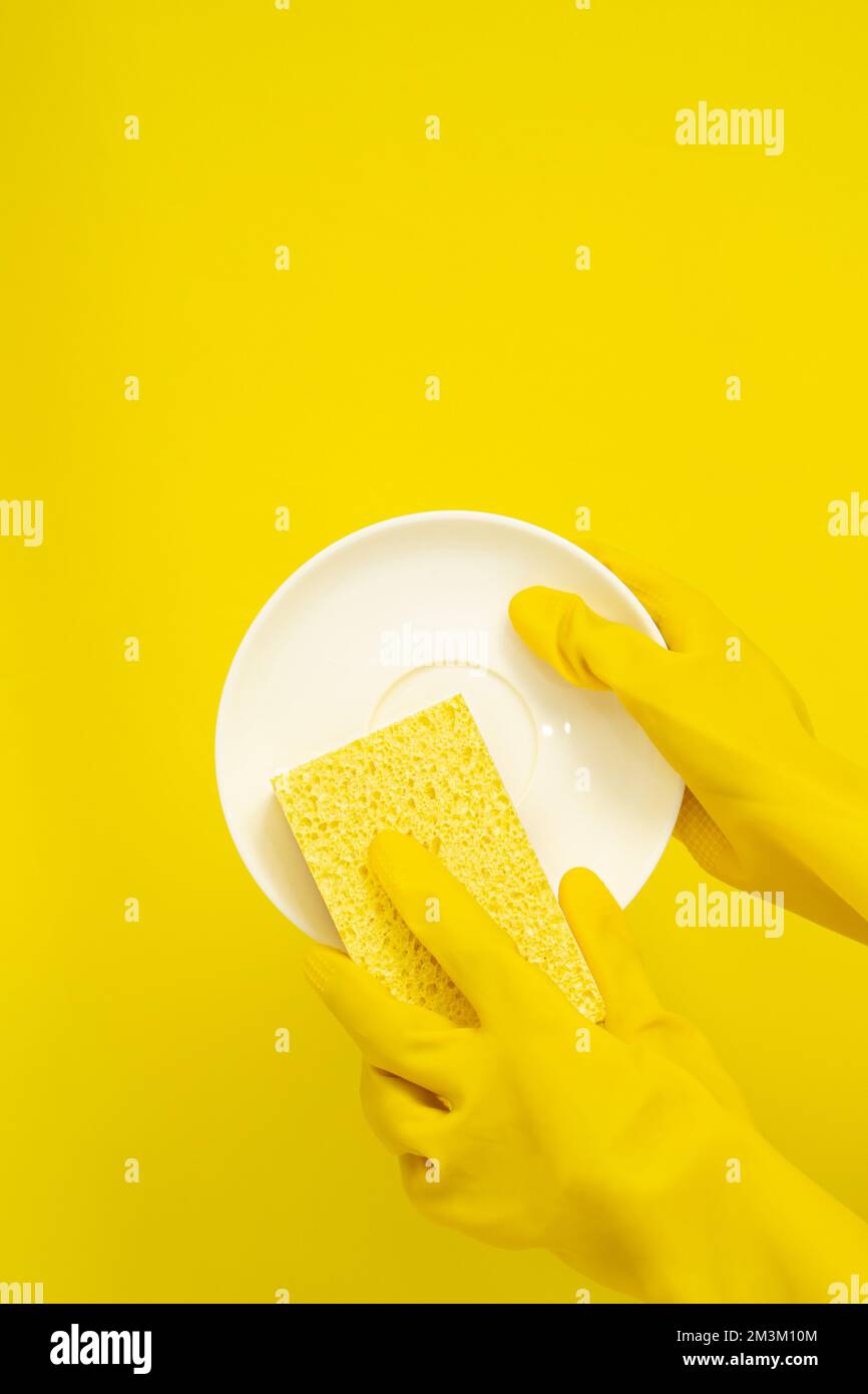 Dishwashing concept, Hands in rubber gloves to holding yellow sponge
