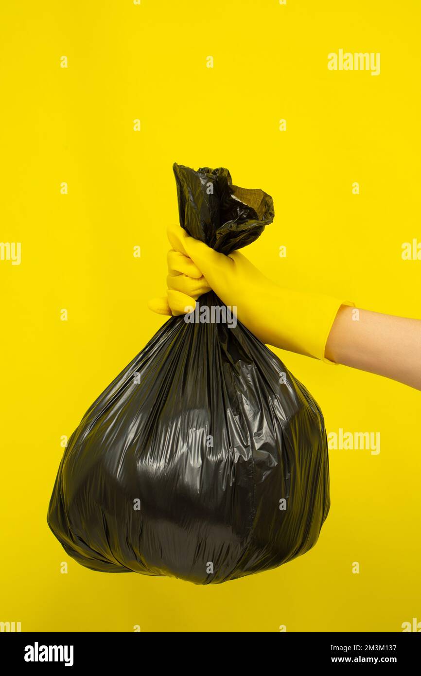 Cleaner concept, Hand in rubber gloves and holding plastic bag with