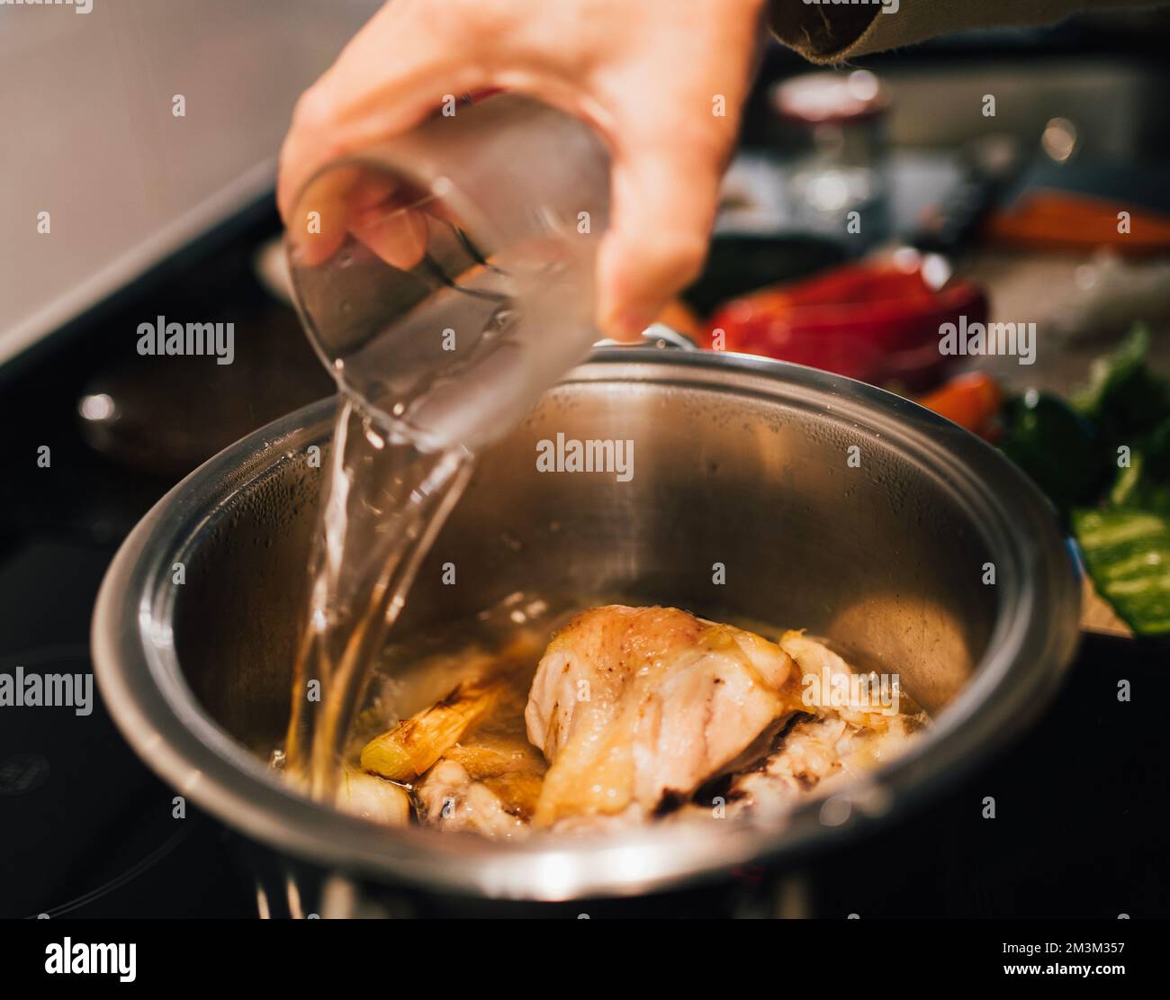 Woman hand adding water on a cooking pot. Preparing chicken soup. Food