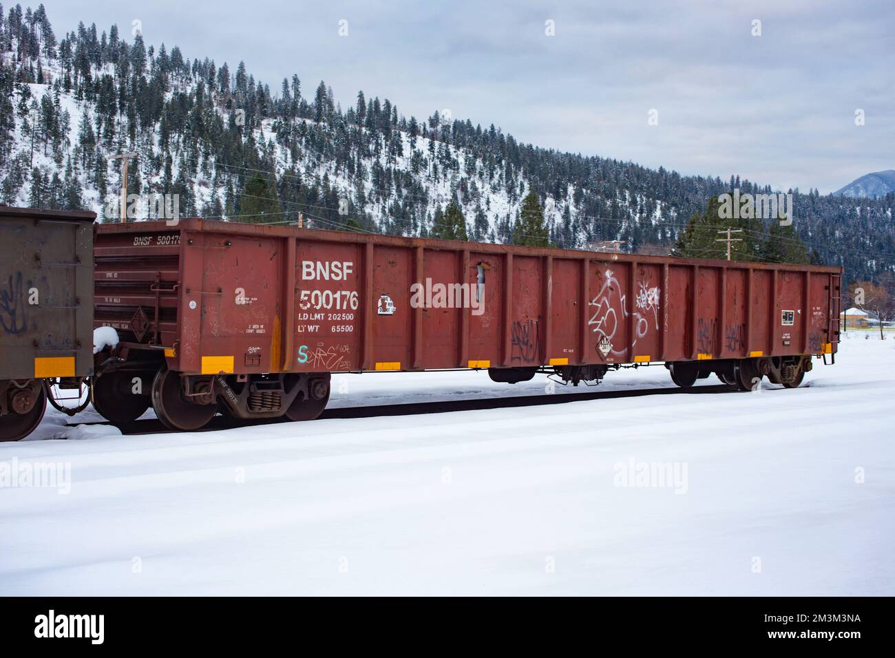 An open railroad gondola car on the tracks at the BNSF train yard, in the town of Troy, Montana