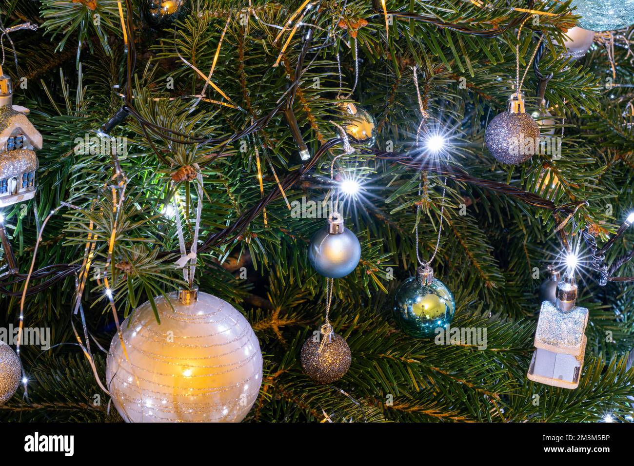 Closeup of a Christmas tree with bauble and light decorations with light stars Stock Photo