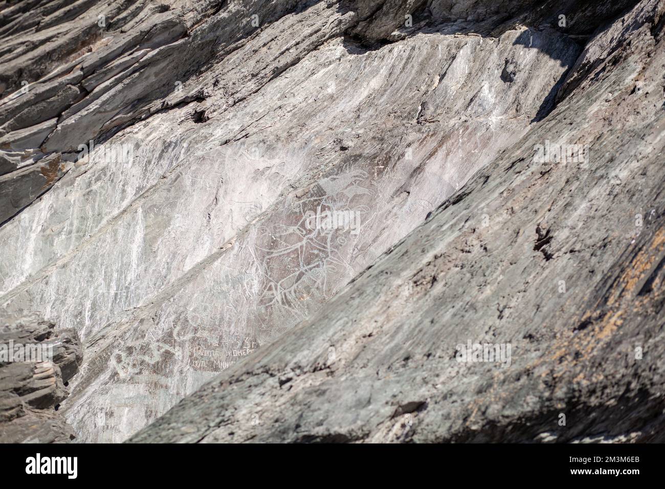 Old rock carvings of an ancient man on rocks in Siberia. The drawings ...