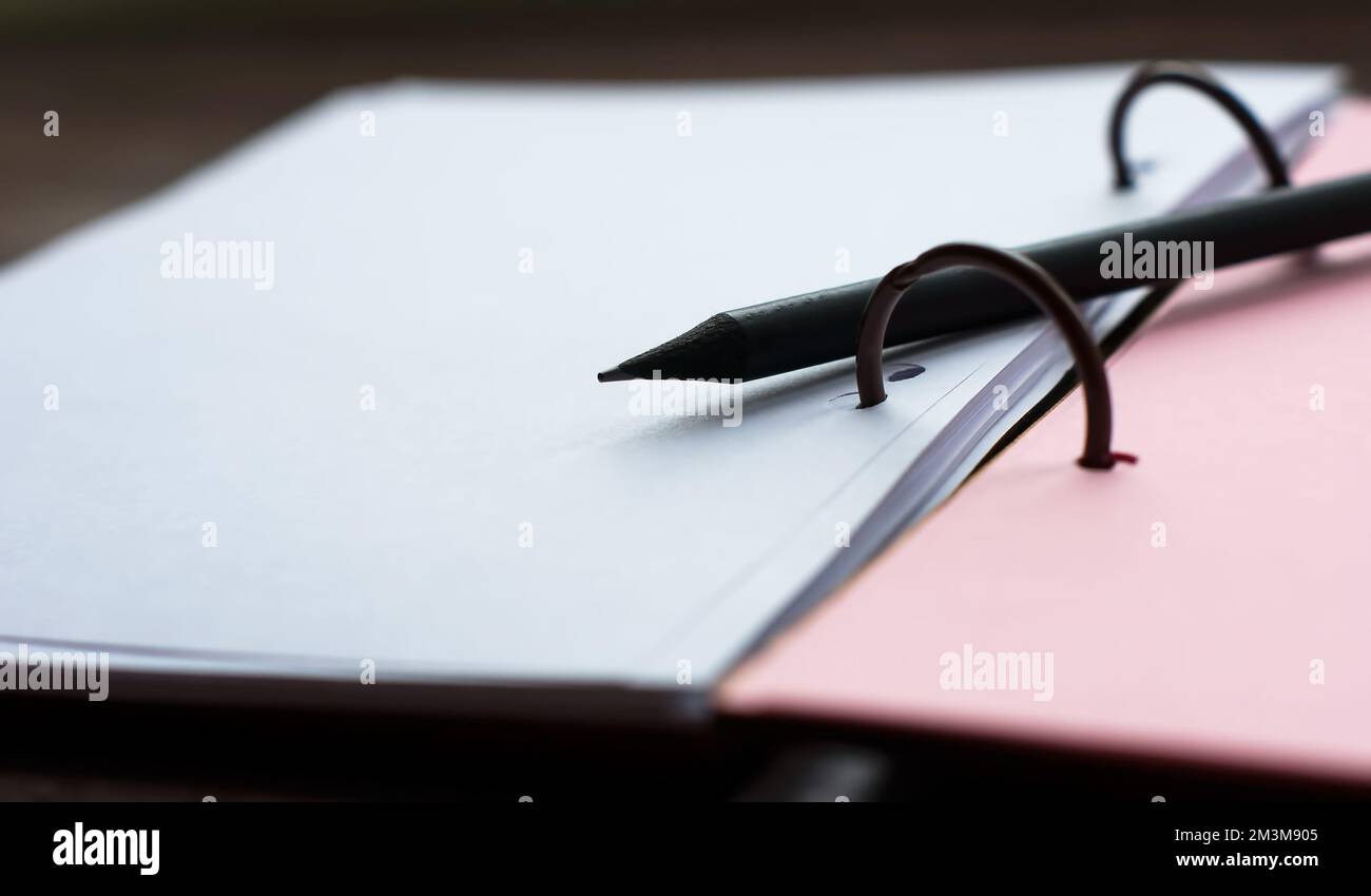 Blank notepad with pink and white pages with black pencil Stock Photo