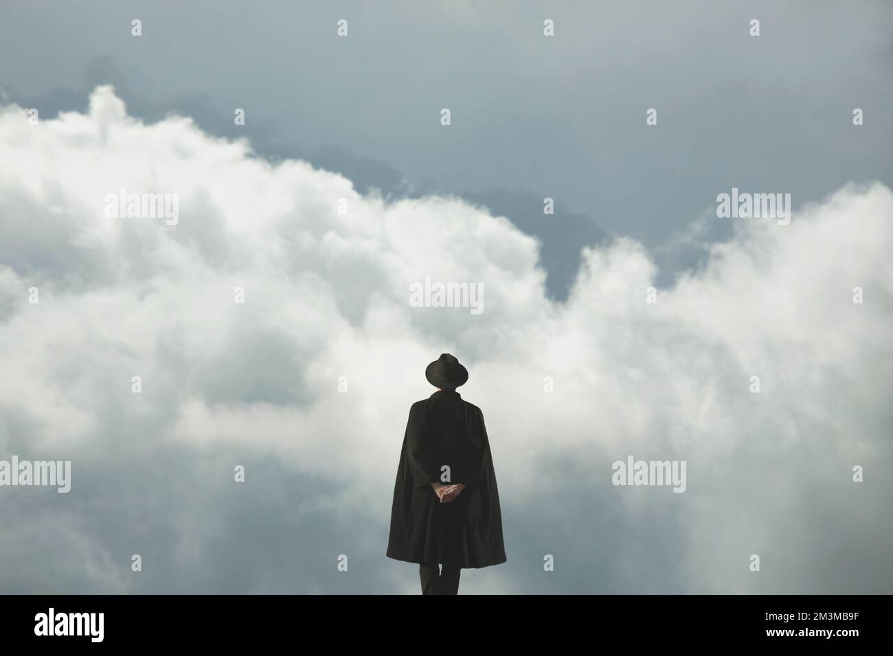 surreal meditative man in front of a cloudy sky Stock Photo