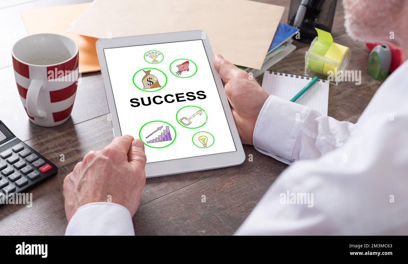 Success concept shown on a tablet held by a man Stock Photo