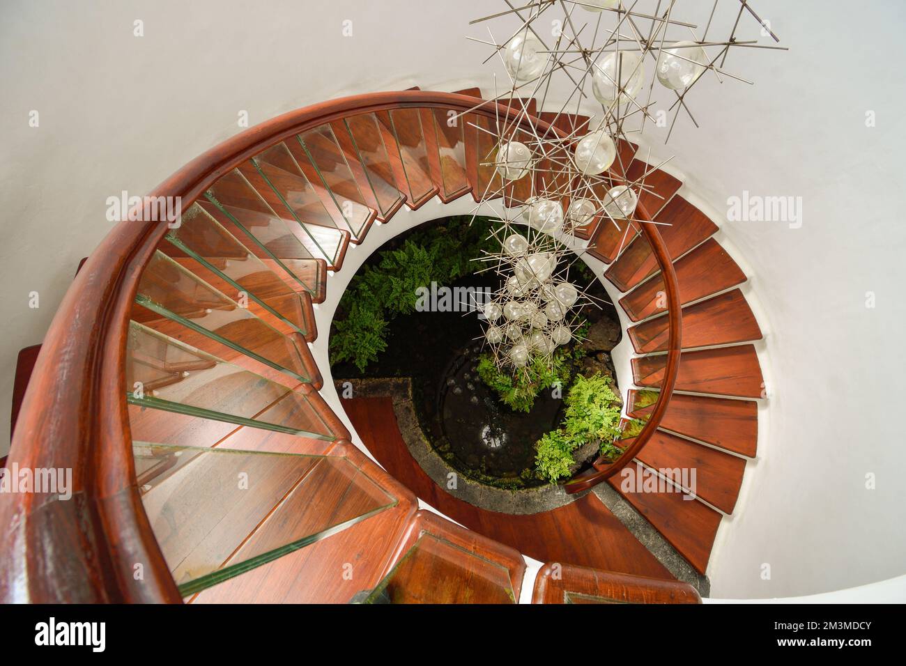 Spiral stairs with hanging lamp in the middle Stock Photo