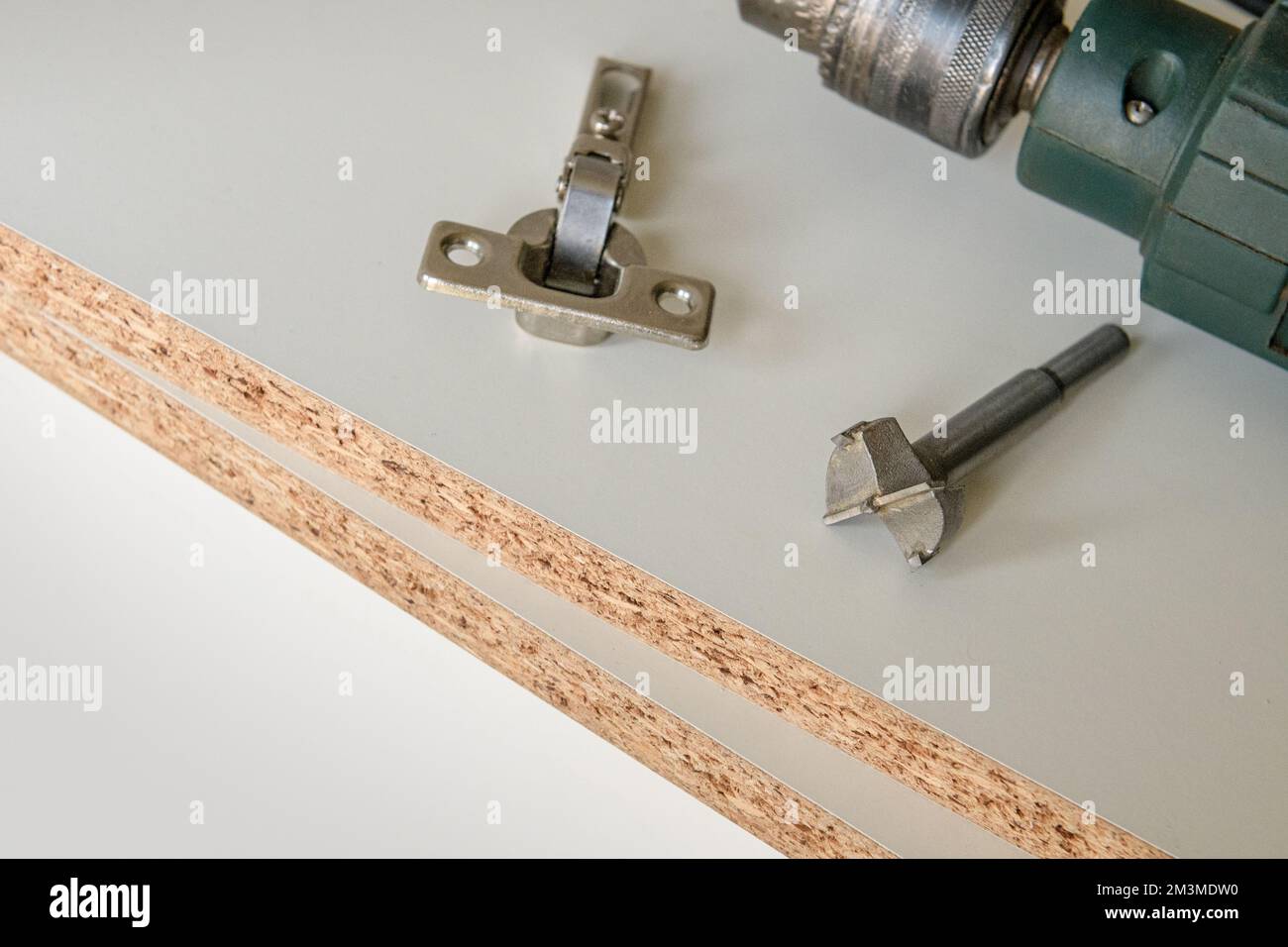 Installation tools for furniture fittings. An attached hinge on a