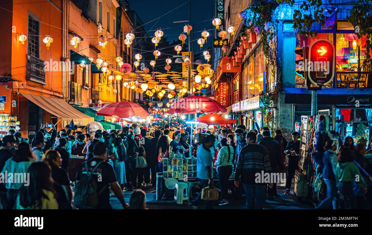 A crowd gathered in a street at night in Mexico City for Day of the Dead parade Stock Photo