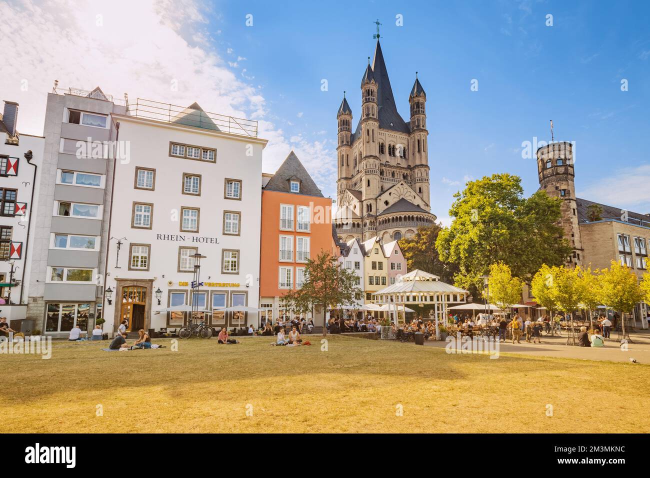 29 July 2022, Cologne, Germany: Fish market square with tourists resting in cafes, colorful houses and St. Martin Church in Koln. Travel and sightseei Stock Photo