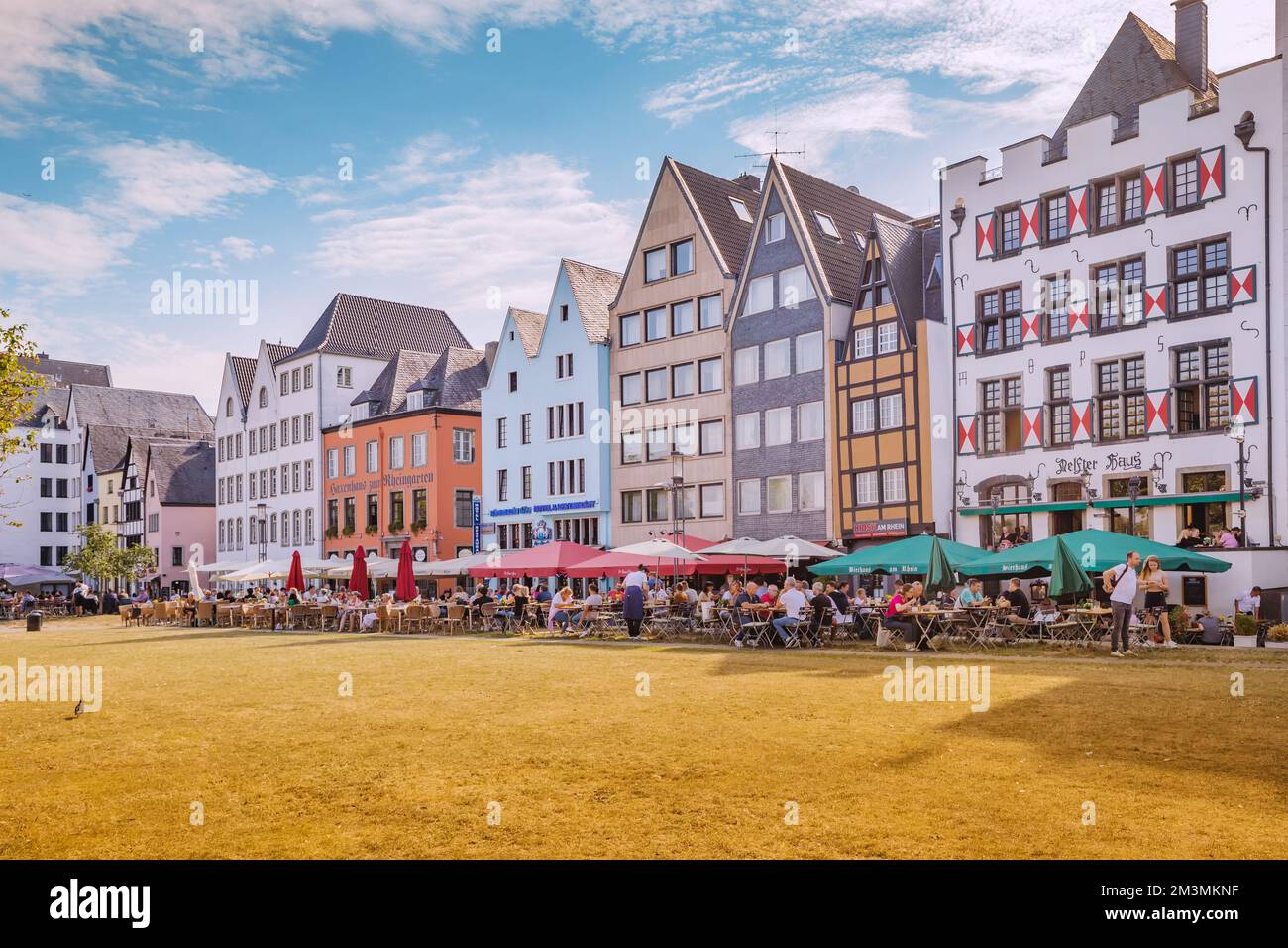 29 July 2022, Cologne, Germany: Fish market square with tourists resting in cafes, colorful houses in Koln. Travel and sightseeing Stock Photo