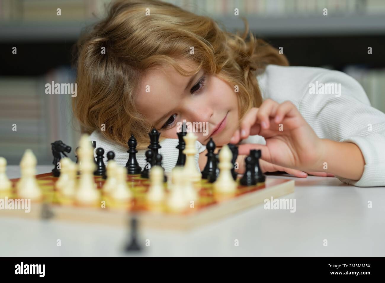 Chess school. Child think or plan about chess game, kids education concept. Intelligent, smart and clever school kids. Kids early development. Boy kid Stock Photo