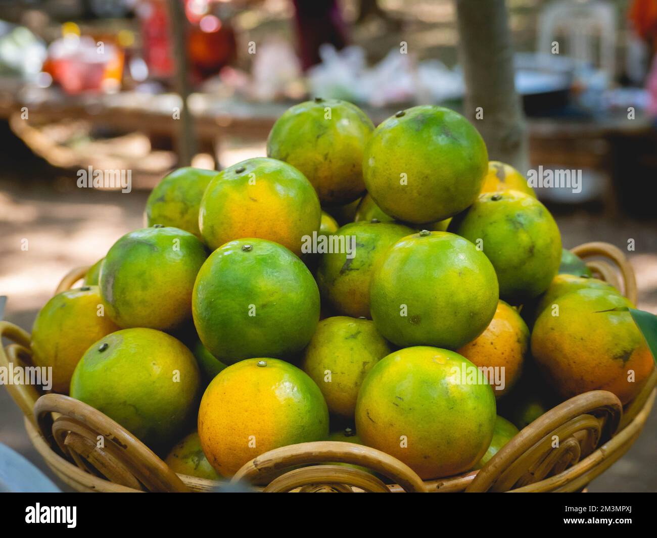 A pile of oranges greenyellow inside the wooden basket Stock Photo Alamy