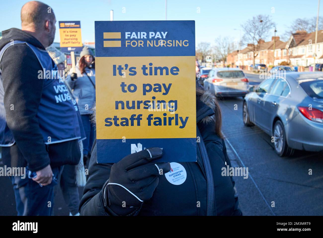 Nurse on the picket line holding up fair pay placards during strike day