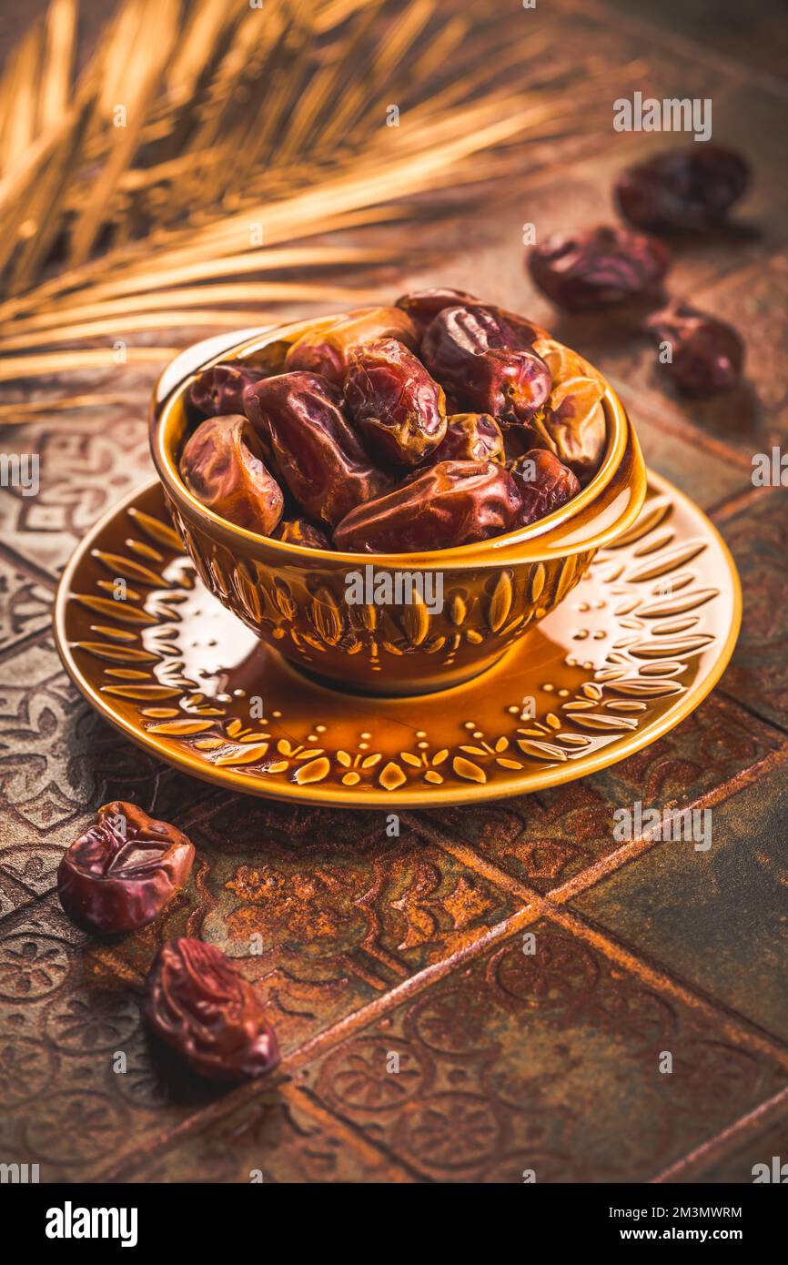 Dried  organic dates in bowl on old kitchen table Stock Photo