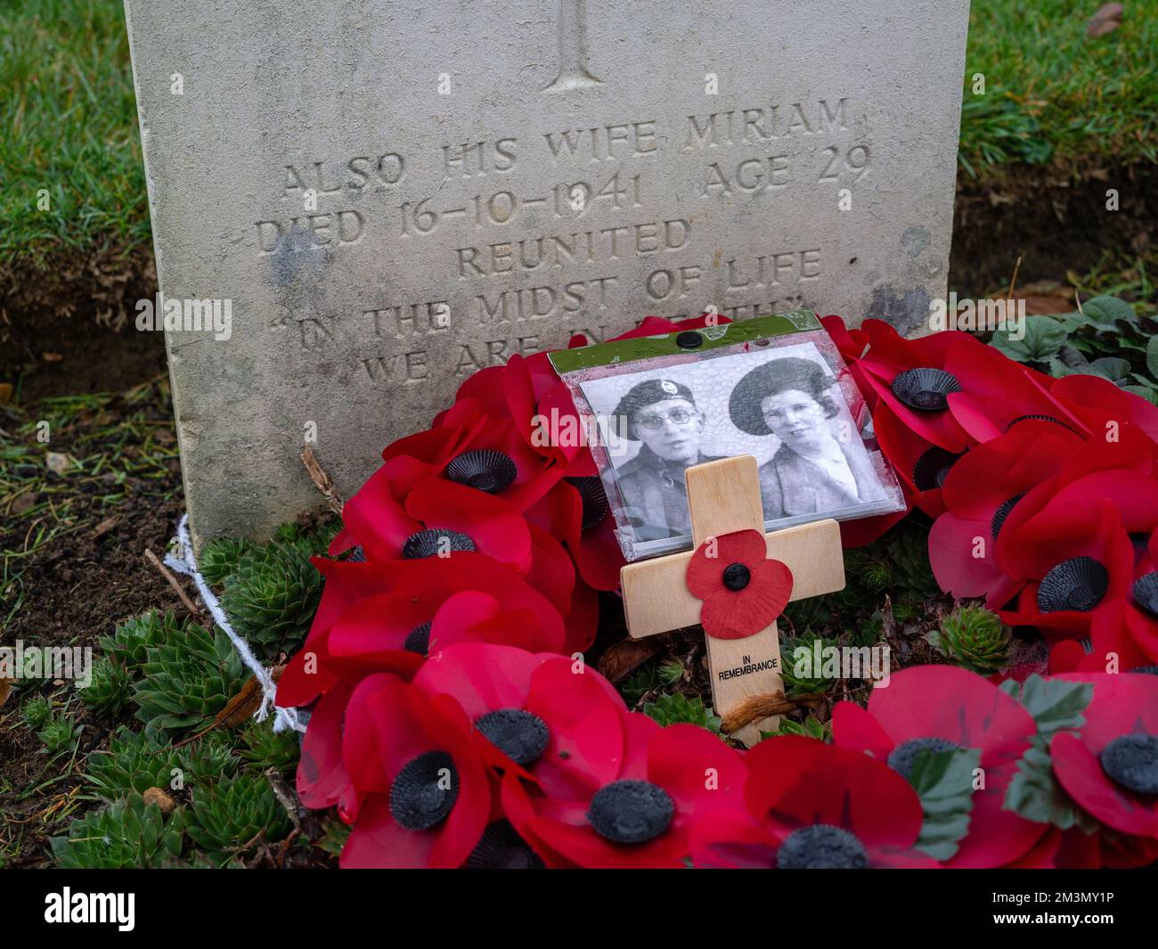 WW1 gravestone in Towcester Road cemetery, Northampton UK; unusually inscribed with name of soldier's wife, with photograph and poppy wreath. Stock Photo