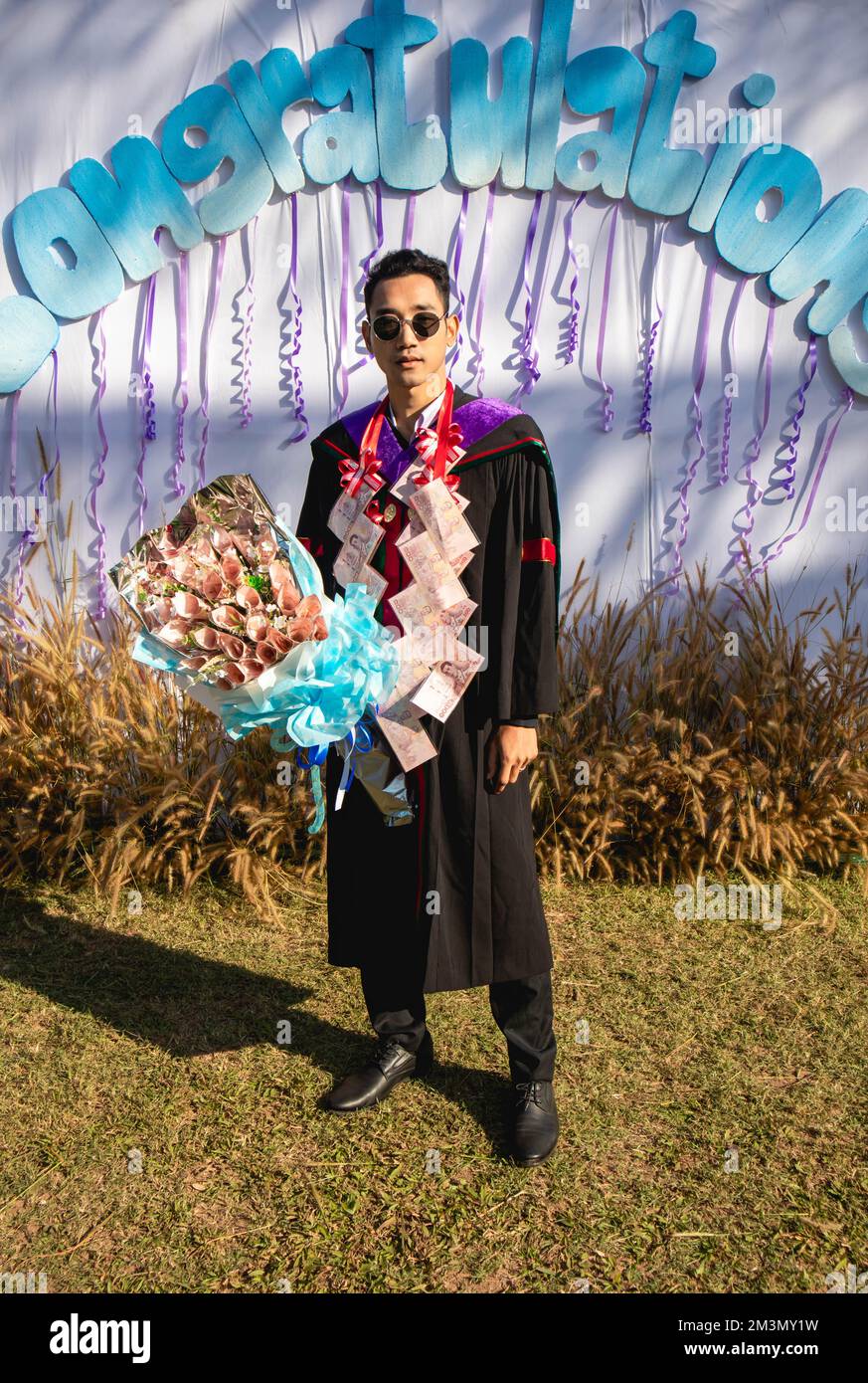 The graduate wore a gown from a university in Thailand. For graduation Stock Photo