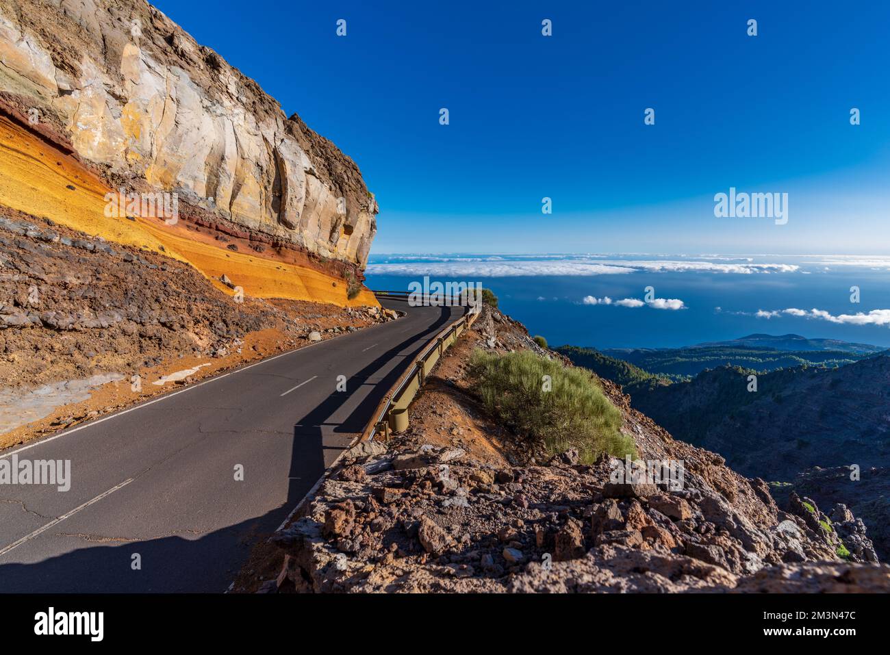 Curved road behind the colorful layers of rocks Stock Photo
