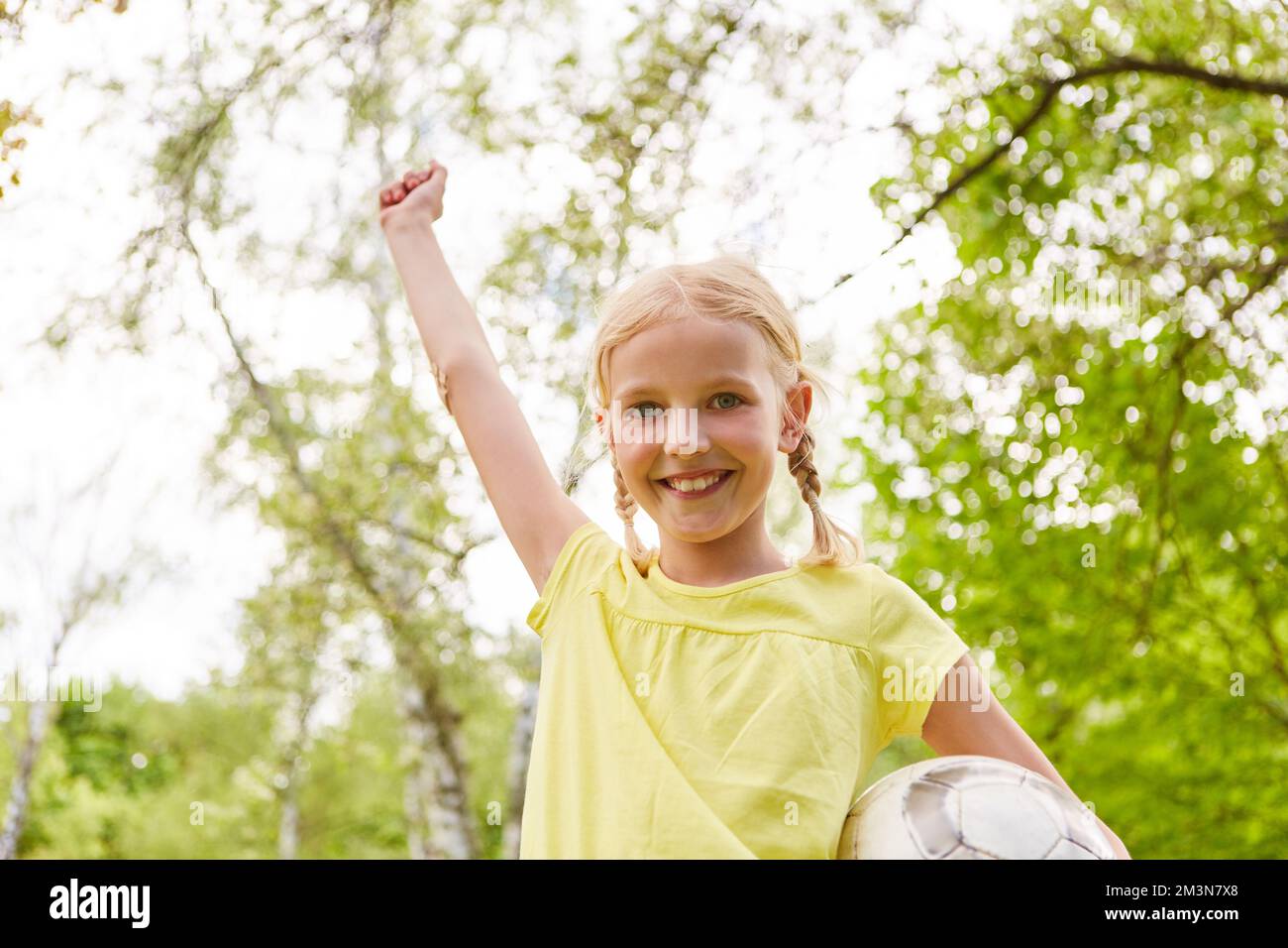 Portrait of cheerful girl winning soccer game in park during summer vacation Stock Photo