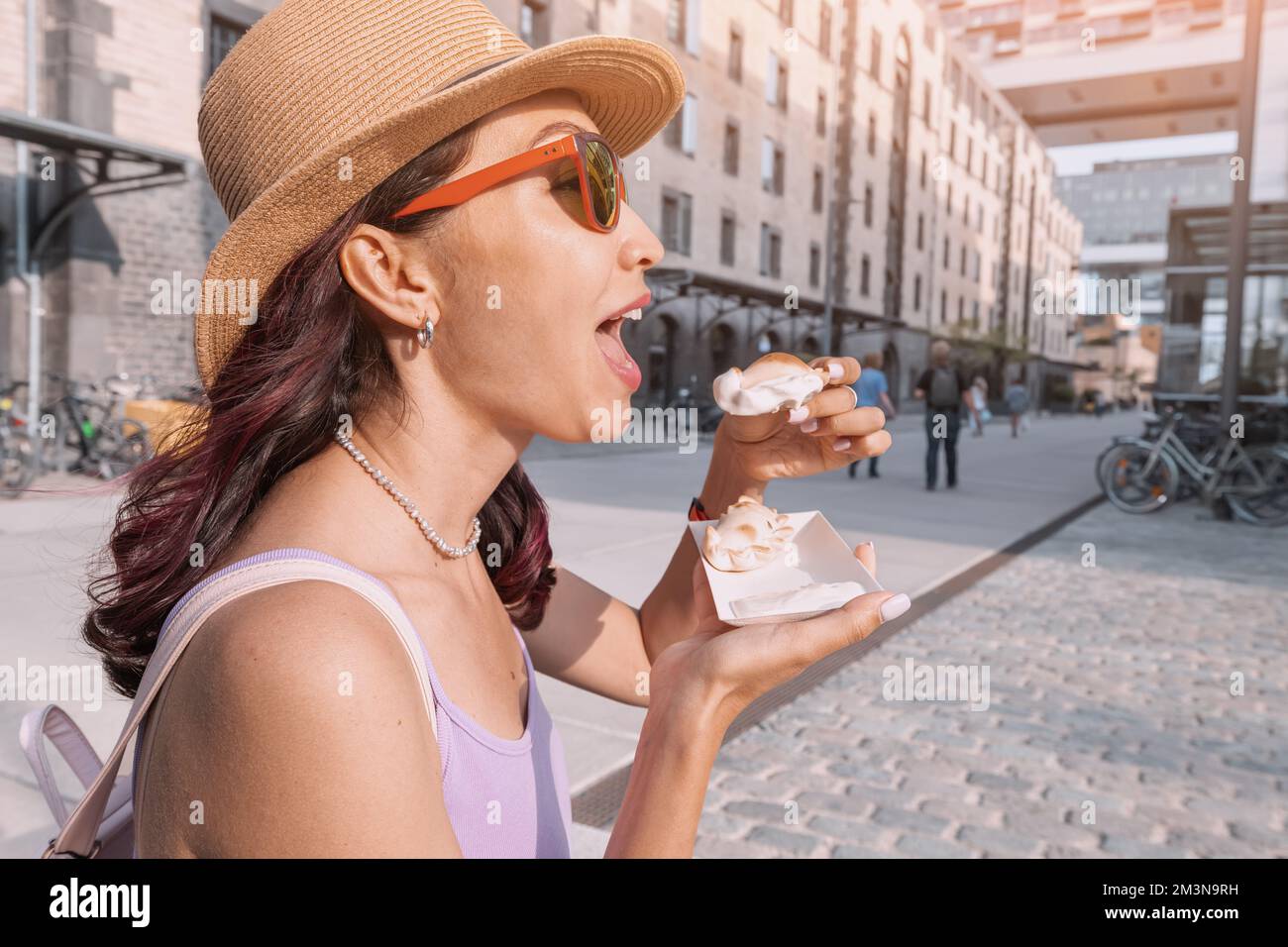 Happy girl has delicious pies with empanadas filling popular in Spain and Argentina. Street food and fast food concept Stock Photo