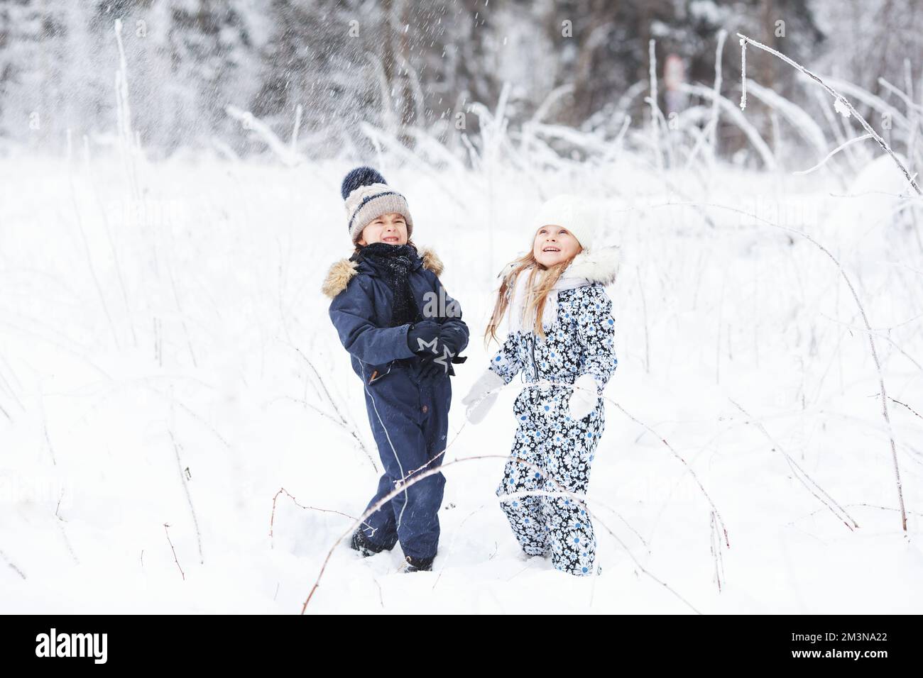 Happy Children playing outdoors in cold winter weather, having fun and