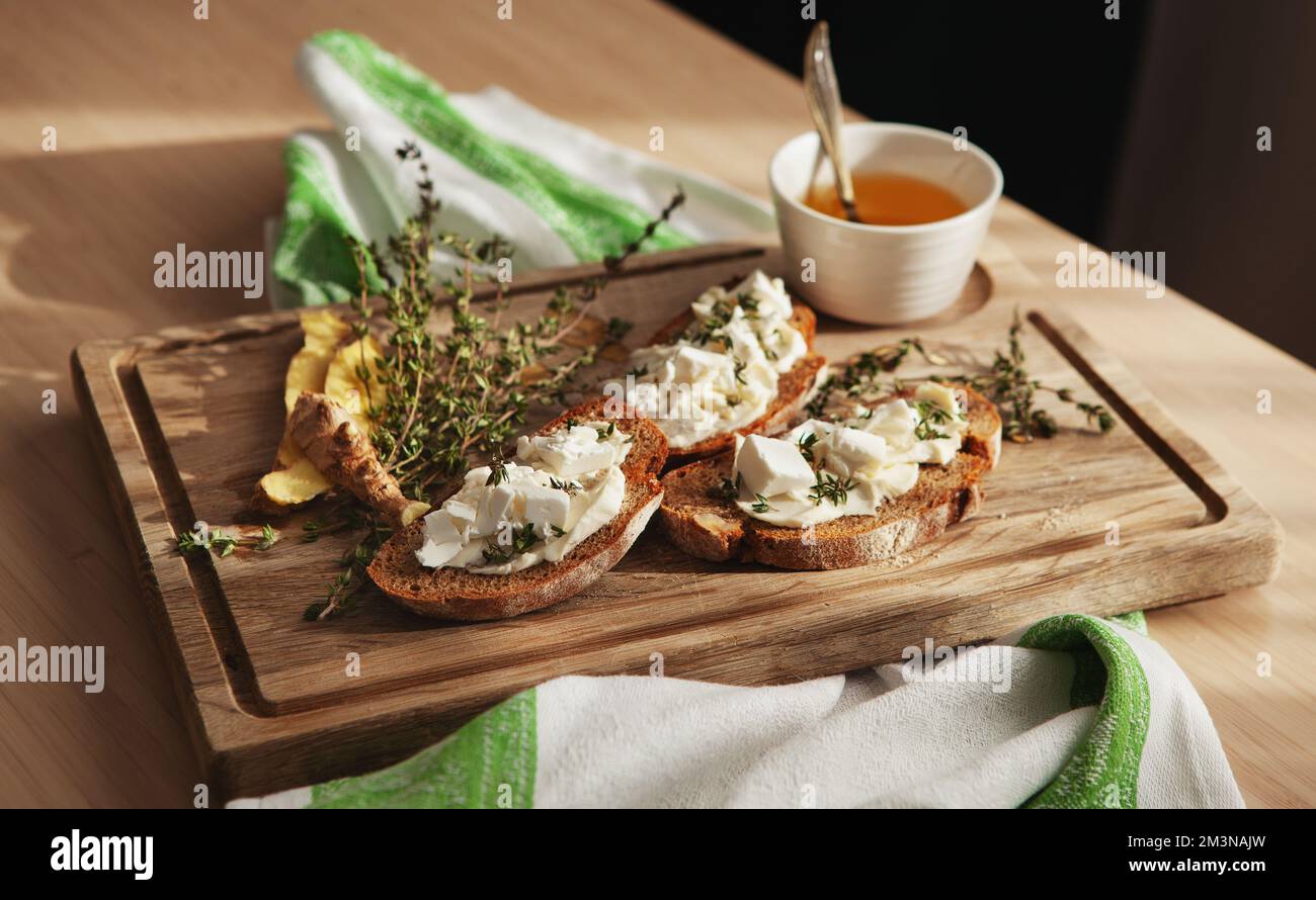Bruschetta with butter or cheese on wooden board. Traditional italian appetizer or snack, antipasto. Delicious food Stock Photo