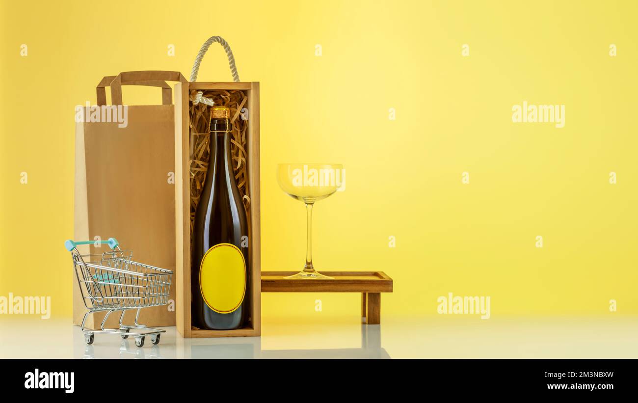 Eco friendly wine shop, wine bar winery or wine delivery concept. Mockup of bottle with champaign in a wooden box with wine glass, paper bag, shopping Stock Photo