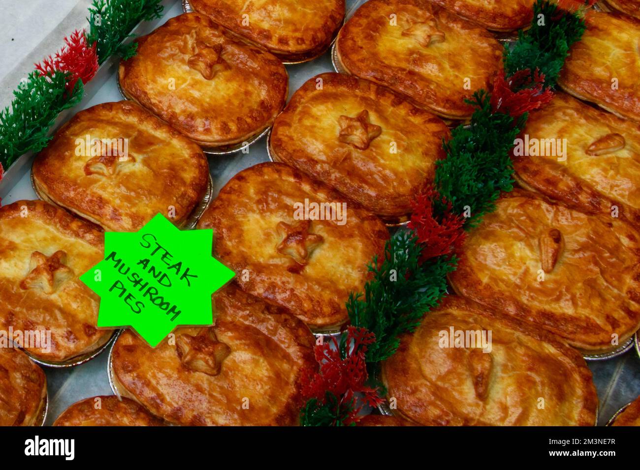 Window display of a British butcher showing steak and mushroom pies, London, UK Stock Photo