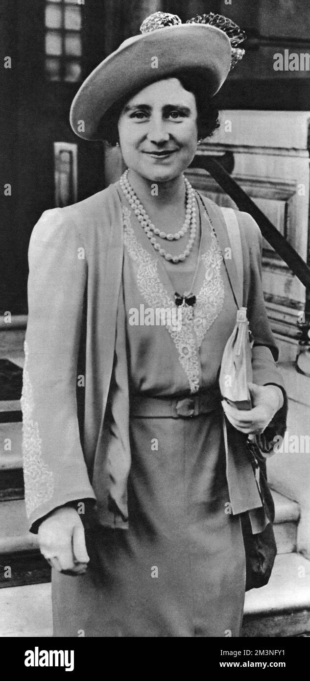 Queen Elizabeth, later the Queen Mother (1900-2002), leaving the headquarters of the British Red Cross Society on 5th September 1939. She carries a gas mask in a canvas bag over her shoulder.     Date: 5th September 1939 Stock Photo